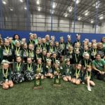 Picture of 2022 season cheerleaders with competition trophies