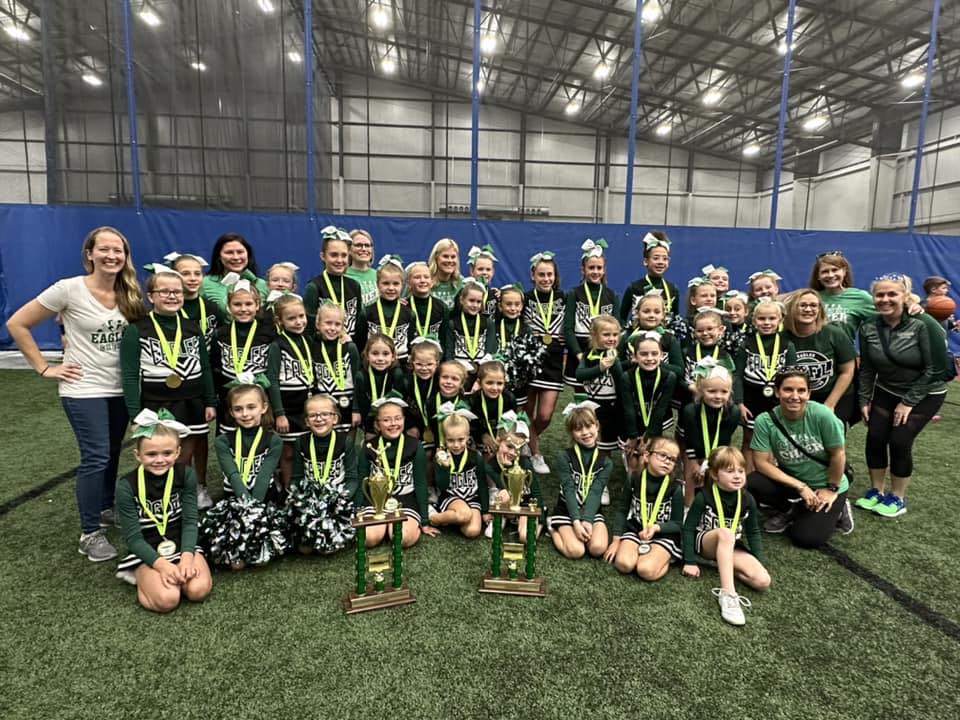 Picture of 2022 season cheerleaders with competition trophies